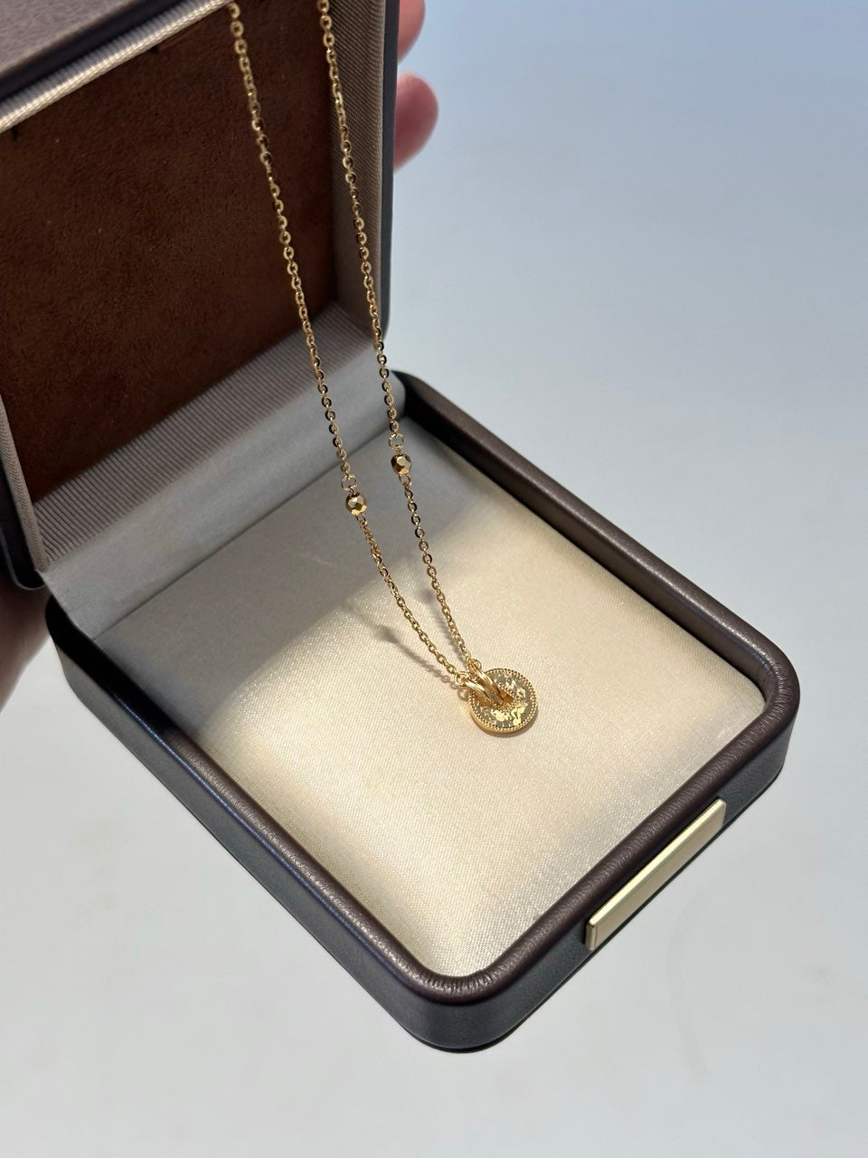 Elysian Jewelry 925 silver with 18k plated gold necklace with a pendant in an open jewelry box on a light gray background