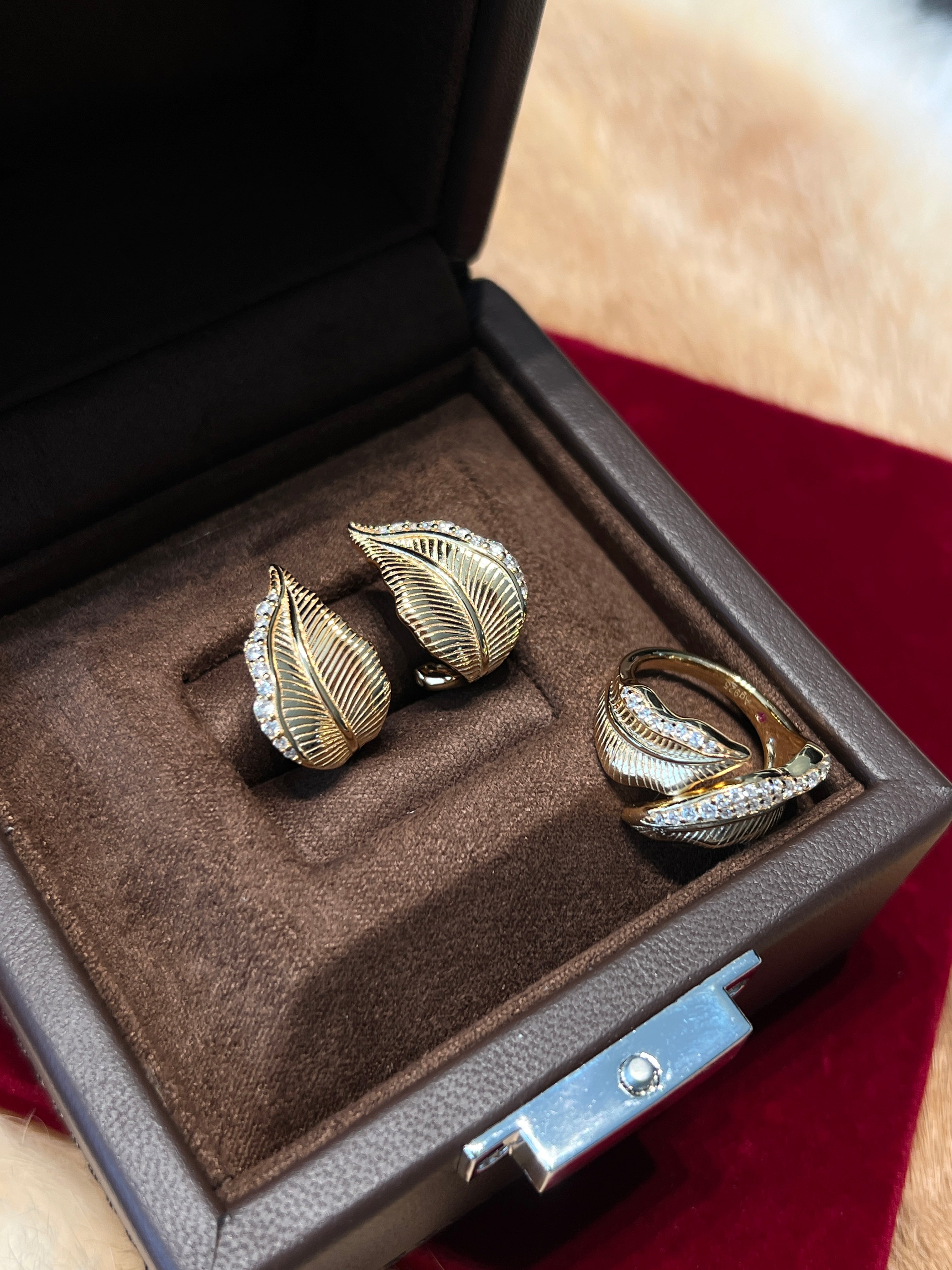 Elysian jewelry 925 silver with 18k plated gold leaf-patterned earrings and ring set in a jewelry box.