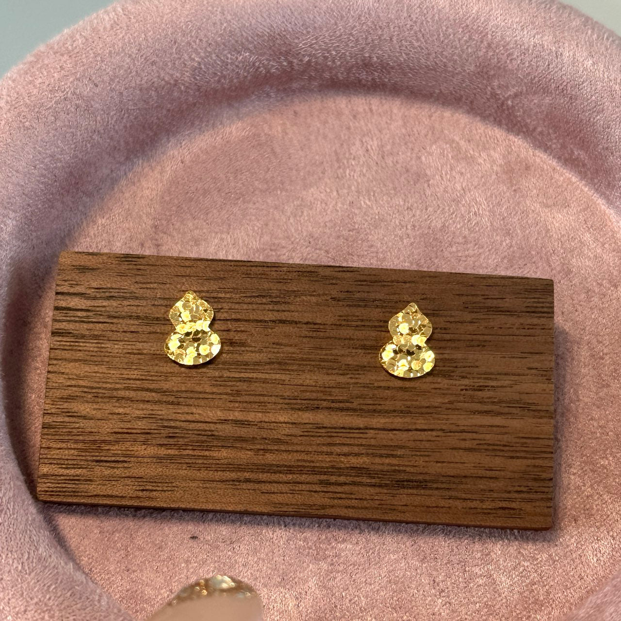 Elysian Jewelry 18k gold-plated 925 silver earrings on a wooden display card with a pink background