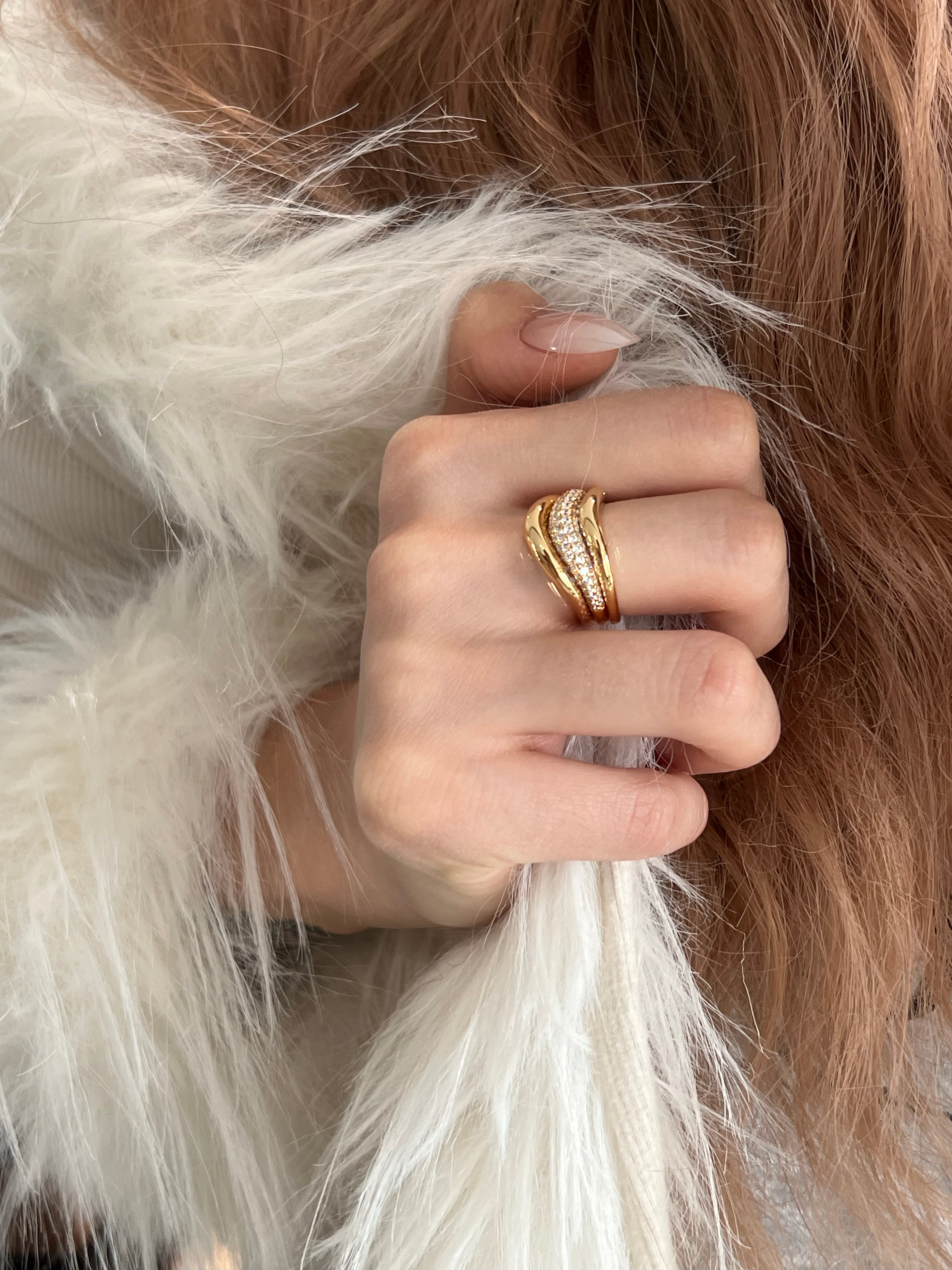 Elysian Jewelry 925 silver and 18k gold-plated close-up of a hand wearing a gold ring with fur in the background