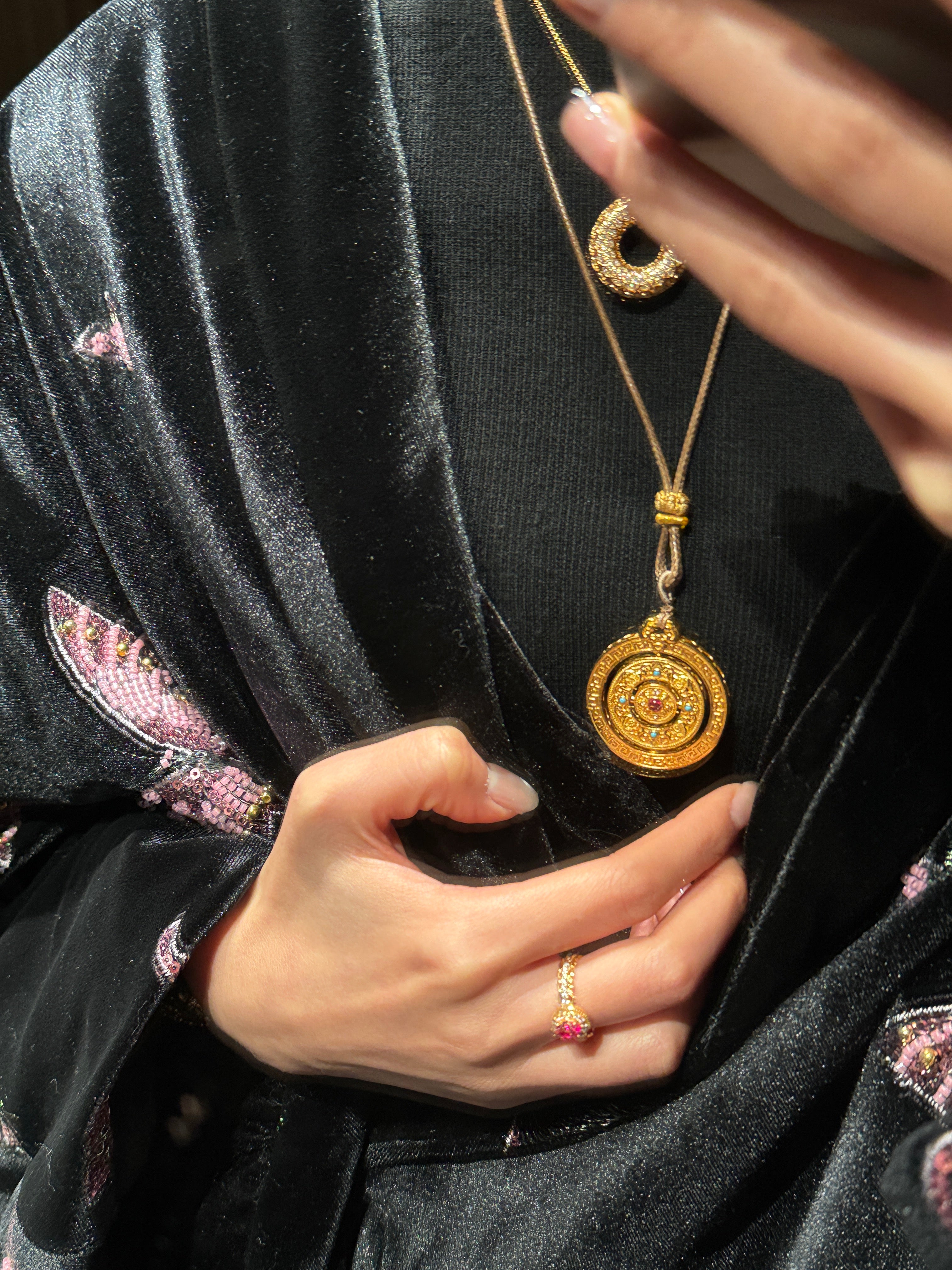 Elysian Jewelry 925 silver with 18k plated gold necklace with a pendant worn by a person against a dark fabric background