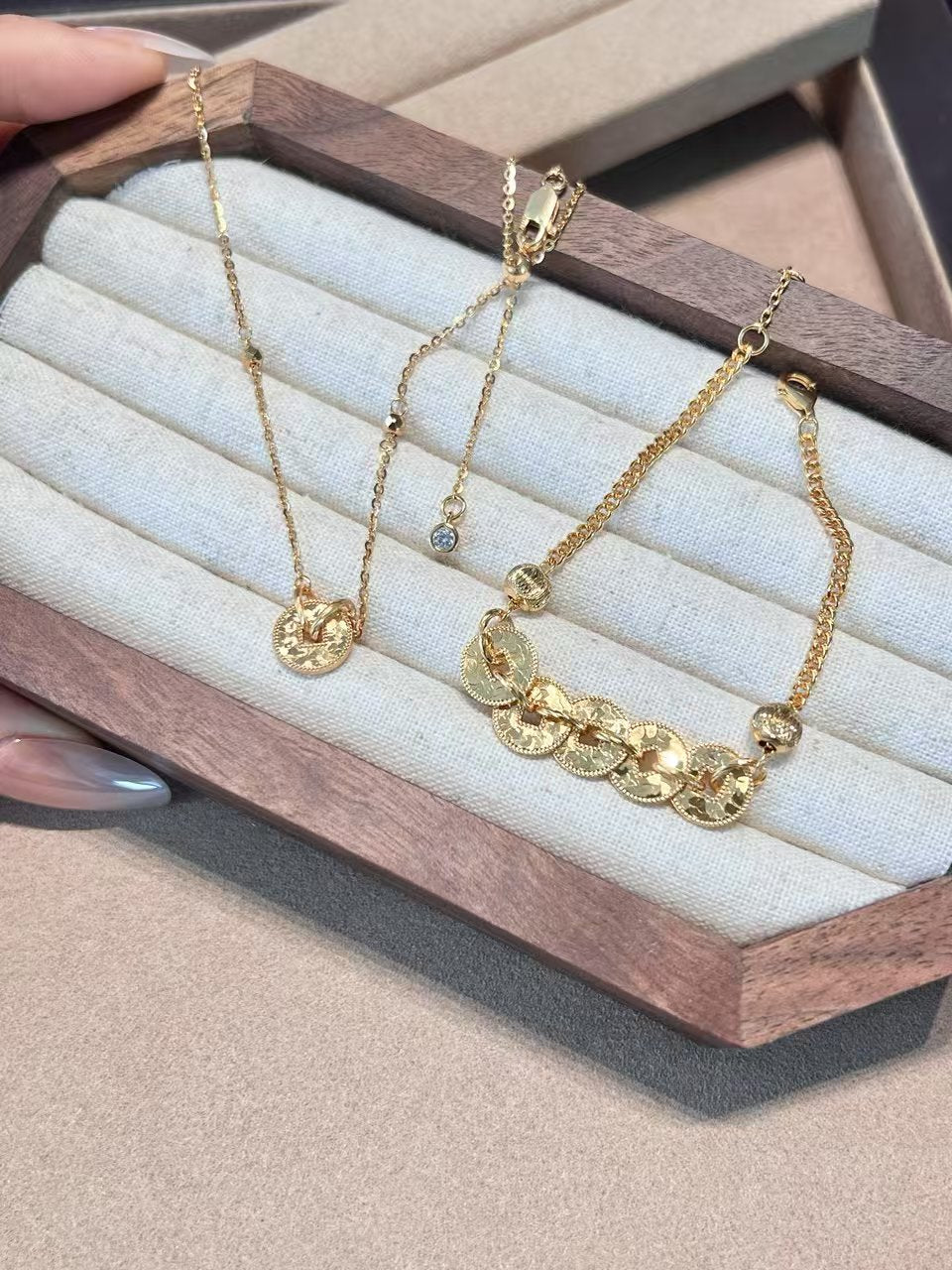 Elysian jewelry 925 silver with 18k plated gold necklaces on a wooden display with a neutral background