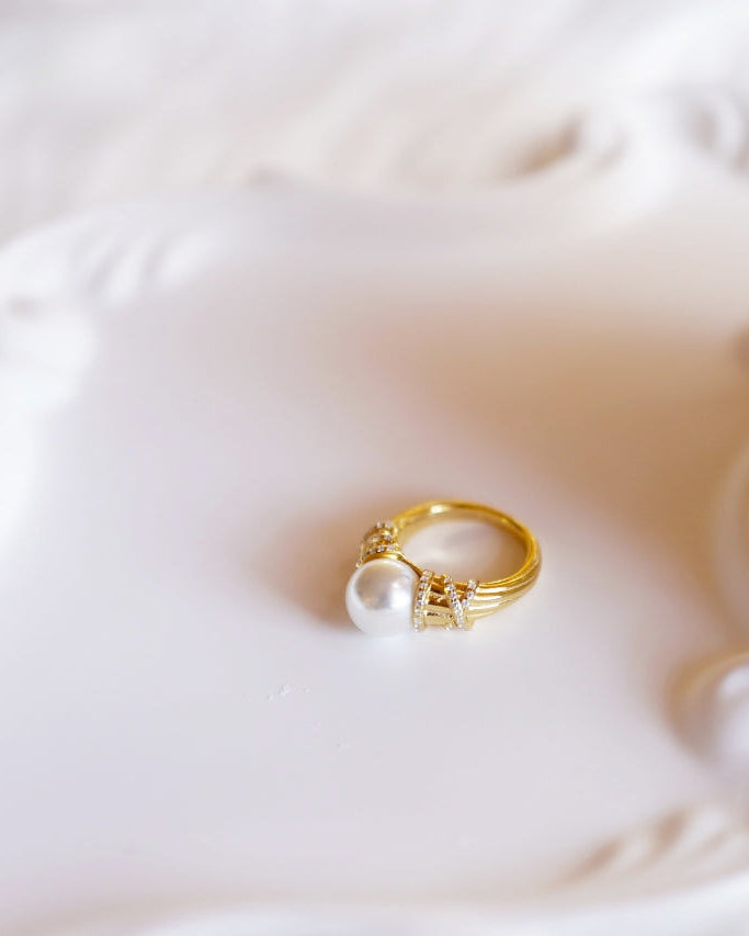 Elysian Jewelry 925 silver with 18k plated gold ring with a pearl on a white shell