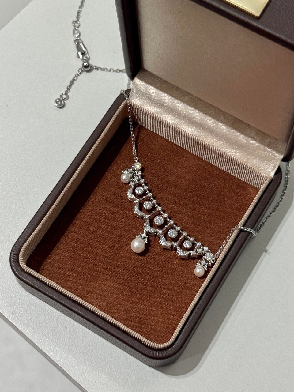Elysian Jewelry 925 Silver necklace with pearls and crystals in a brown jewelry box on a light gray surface
