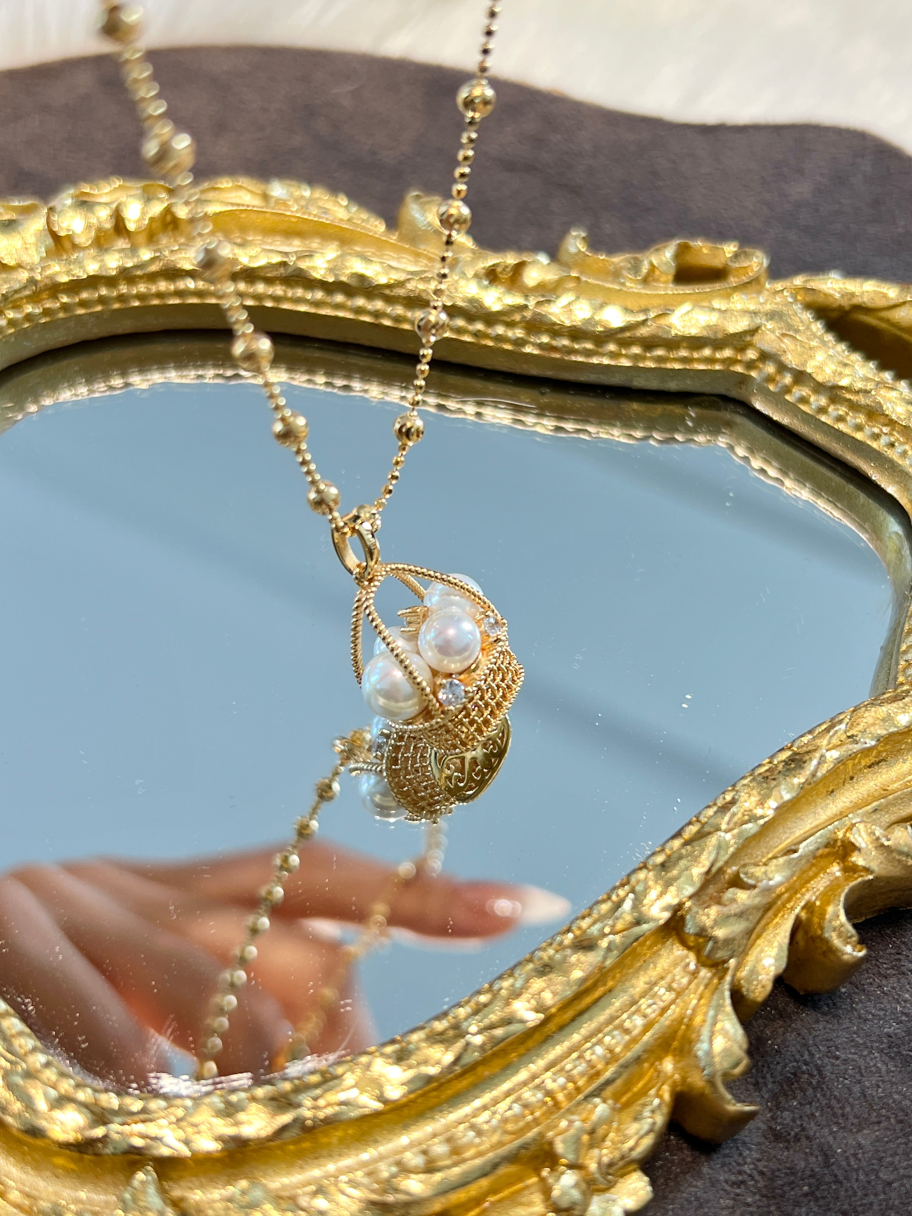 Elysian Jewelry 925 silver with 18k plated gold necklace with pearls in front of a decorative mirror