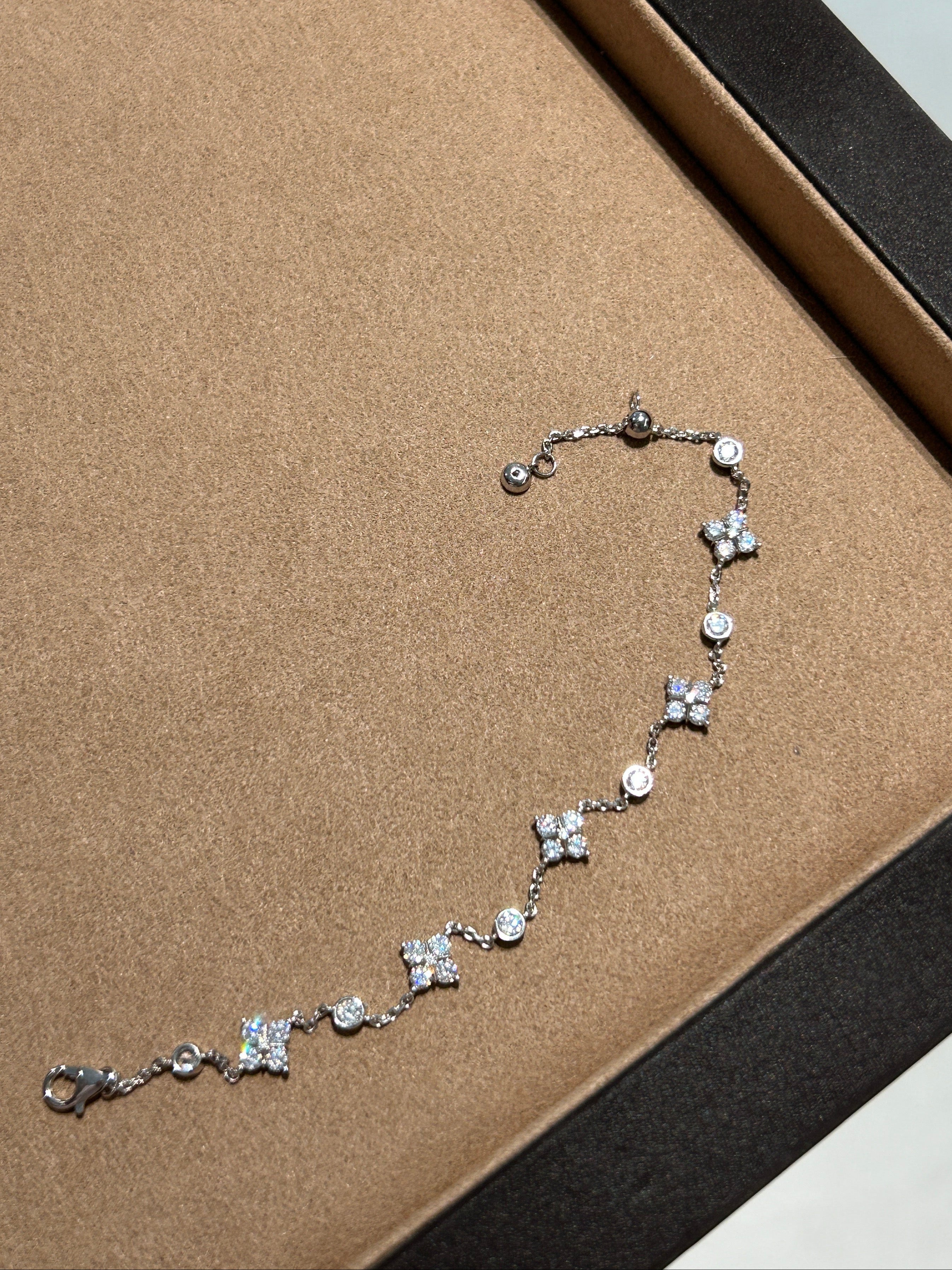 Elysian Jewelry 925 silver bracelet with floral designs on a brown display box